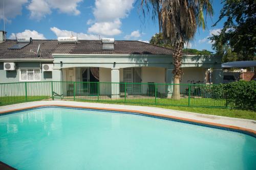 哈博罗内Haithoms Guesthouse的房屋前的大型游泳池