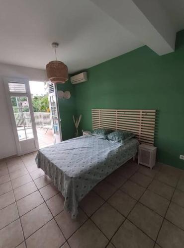 舍尔谢Bas de villa spacieux, proche plages et centre的卧室设有一张位于绿色墙壁上的床铺