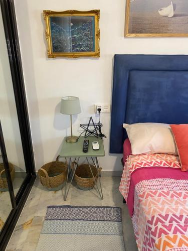 阿尔姆尼卡Apartamento con vistas en Mariote的一间卧室配有一张带蓝色床头板的床和一张桌子