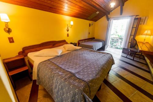 彼得罗波利斯Pousada Imperial Koeler的一间卧室设有一张床和黄色的墙壁