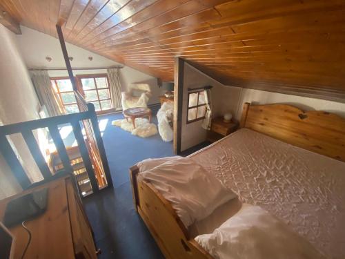 代米考迪亚Appartement face Mont Blanc的一间卧室设有一张床和木制天花板