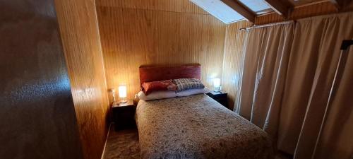 Puerto del YateCabañas camelia2的一间小卧室,配有一张带两个灯的床
