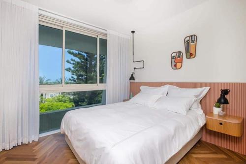 凯撒利亚lasuita- exclusive suites cesarea- sea view suite的卧室设有白色的床和大窗户