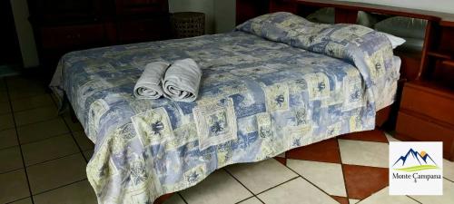 BirríHotel Monte Campana Heredia的一张带蓝色棉被和毛巾的床
