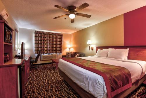 俄克拉何马城俄克拉何马城机场北部华美达酒店的酒店客房配有一张床和吊扇。