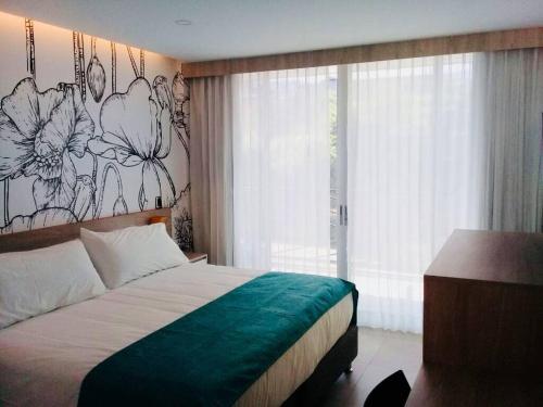 梅尔加Hotel Karmel的卧室配有一张挂着花壁画的床。