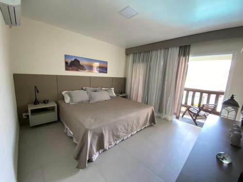 布希奥斯Buzios Beach Resort Super Luxo Residencial 2501 e 2502的一间带大床的卧室和一个阳台