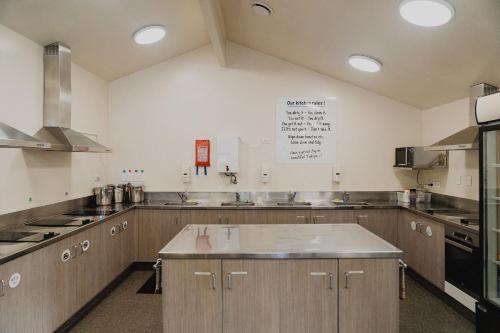 特卡波湖Lakes Edge Lodge的一个带木制橱柜和不锈钢用具的大厨房