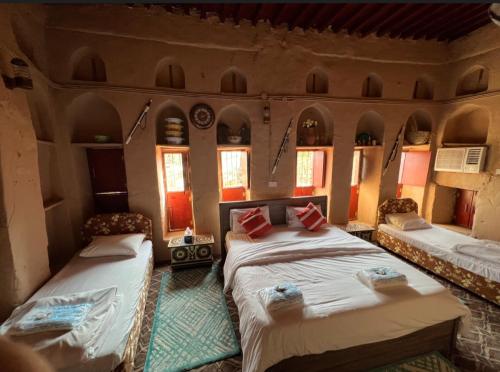 Misfāh阿尔密斯法温馨旅馆的一间带两张床的卧室,位于带窗户的房间内