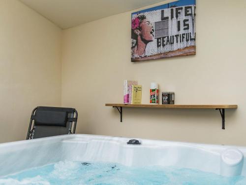 奇勒姆Kentish Barn Retreat的浴缸位于墙上标牌的房间