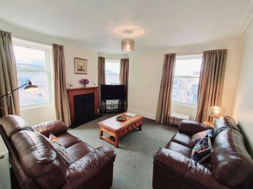 因弗内斯Highland Historical Home in Inverness City Centre的客厅配有两张真皮沙发和一张桌子