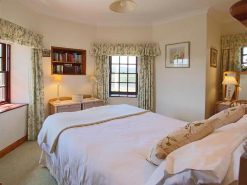 Kingholm QuayConheath Gatelodge Cottage的卧室设有一张白色大床和两个窗户。