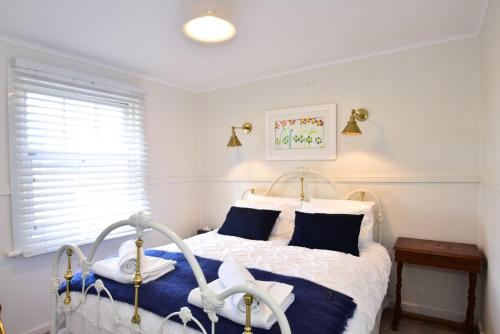 达博Farm Cottage close to Dubbo的一间卧室配有白色床和蓝色枕头