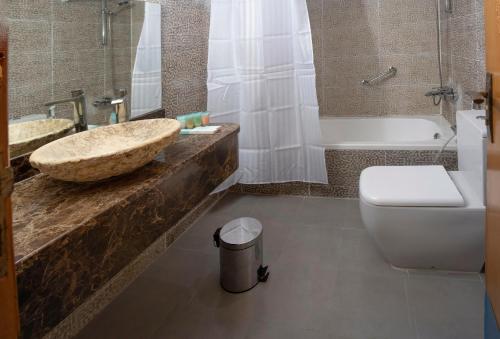 豪尔费坎Sea Shore Hotel Apartment Khorfakkan的一间带水槽、浴缸和卫生间的浴室