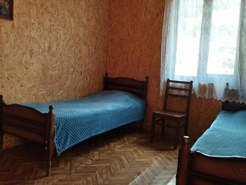 AkhmetyMakratela的一间卧室设有两张单人床和一个窗户。