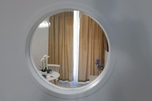 泰拉奇纳Il Grande Blu的白色房间中的镜子,配有桌子和窗户