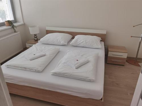 鲁容贝罗克Apartmán RUŽA的一张白色的床,上面有两个白色的枕头