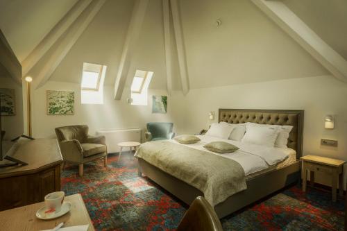 布加勒斯特La Boheme的一间卧室配有一张大床和一把椅子