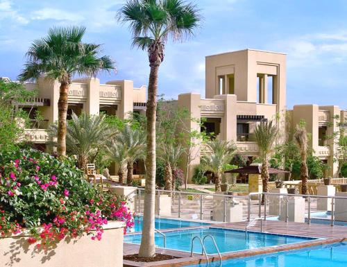 索瓦马死海假日酒店的一个带游泳池和棕榈树的度假村