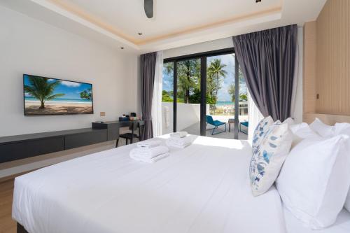 芭东海滩By The Beach Home in Patong的卧室设有白色床,享有海景