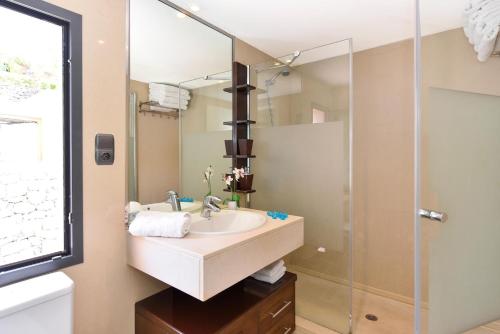 马斯帕洛马斯Holiday Home Villa Gema, spacious, scenic, Wlan ,AC的一间带水槽和玻璃淋浴的浴室