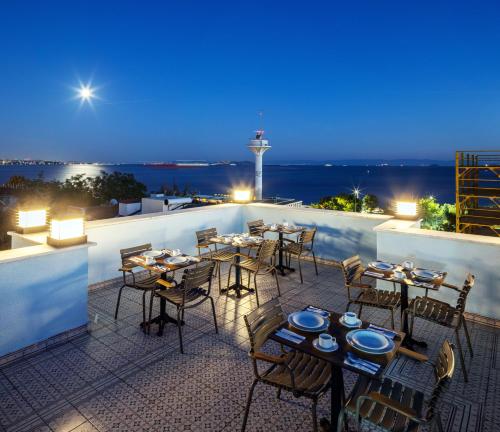 伊斯坦布尔HOME QUALITY HOTEL的一间晚上在屋顶上设有桌椅的餐厅