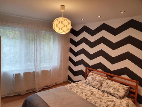 比斯特里察RZA Apartment的一间卧室配有一张床和一面 ⁇ 形墙