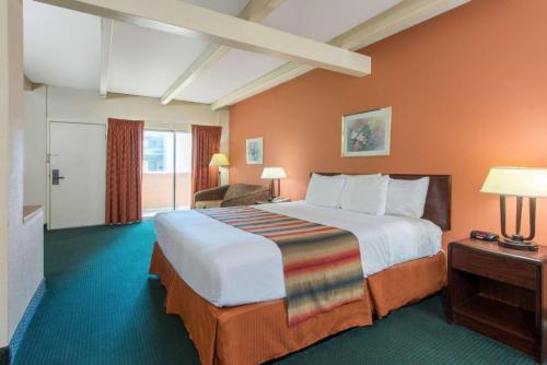 黑泽尔伍德Haven Inn & Suites St Louis Hazelwood - Airport North的酒店客房,设有一张带橙色墙壁的大床