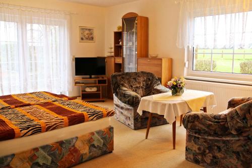 奥斯赛拜-屈隆斯博恩Ferienhaus in Kühlungsborn的一间卧室配有一张床、一把椅子和一张桌子