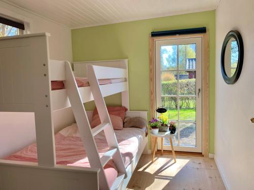 TjørneholmSpacey and charming cabin 300 m. from beach的一间卧室配有双层床和窗户。