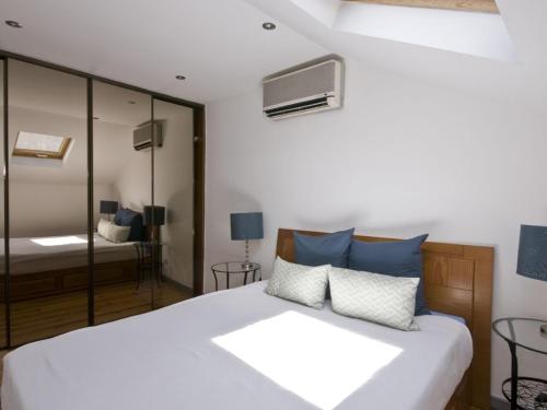 里斯本Casa em Lisboa的卧室配有带蓝色枕头的大型白色床