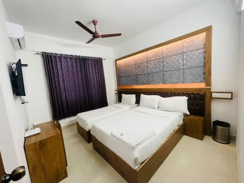 班加罗尔B Six Hotel的一间卧室配有两张床和吊扇