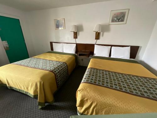 利柏提Kansan Motel的两张位于酒店客房的床,配有黄色和绿色床单