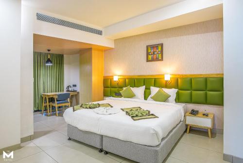赖布尔THE M HOTEL的一间卧室配有一张大床和绿色床头板