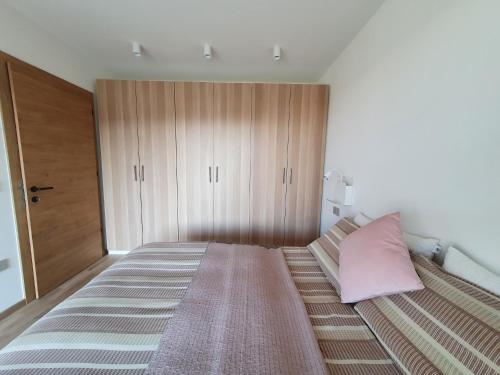 博尔扎诺New Great Apartment Bolzano with 25m pool的一间卧室配有一张带粉红色枕头的大床