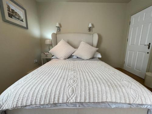 阿伯加文尼Ty Llew Lodge的卧室配有白色的床和2个枕头