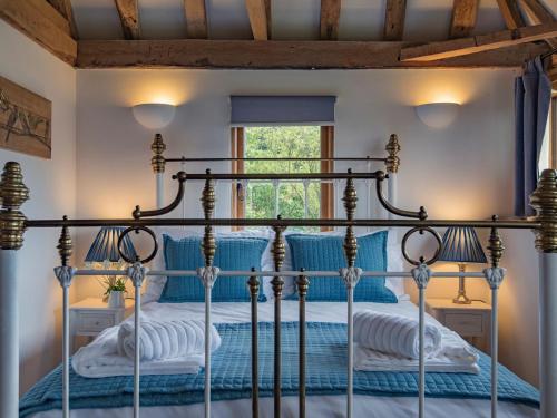 HollingbourneHeron Barn的一间卧室配有一张带蓝色床单的四柱床