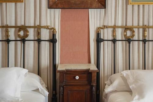 布尔戈斯兰达酒店的一间卧室设有两张床和木制床头柜