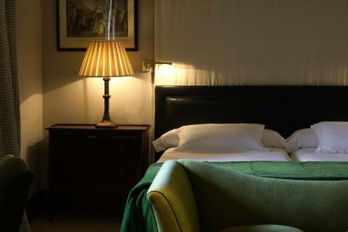 布尔戈斯兰达酒店的一间卧室配有一张带台灯的床铺,