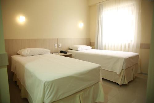 因佩拉特里斯Stay Inn Hotel的配有窗户的酒店客房内的两张床