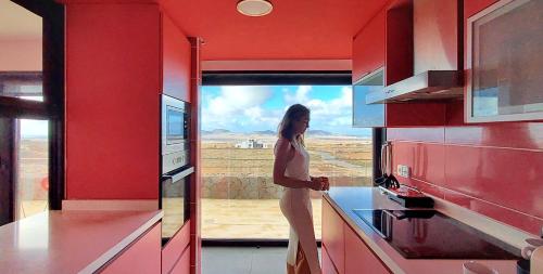 维拉韦德Luxury Villa Sand Volcano的站在厨房里,望着窗外的女人