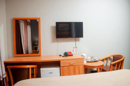 布兰太尔Top Lodge in Blantyre的客房设有带镜子的书桌和电视。