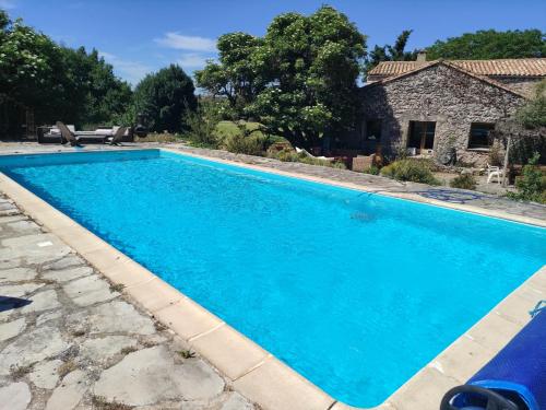 BlandasGîte de Navacelles的一座大蓝色游泳池,位于房子前