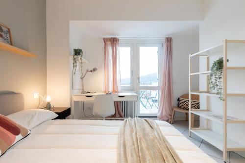 都灵Top Living Apartments - Carducci的一间卧室设有两张床、一张桌子和一个窗口。