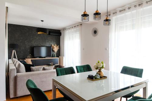 奥西耶克ARENA的客厅配有白色桌子和绿色椅子