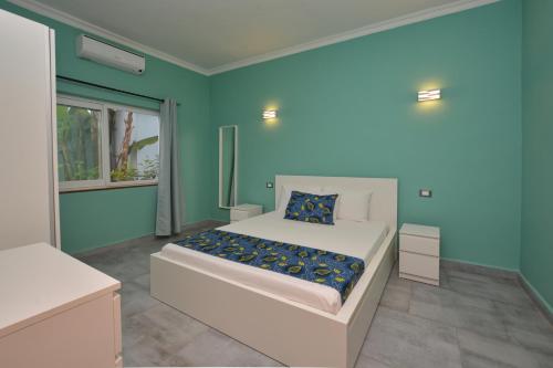 吉汶瓦Bless Villa Apartment的一间卧室配有一张蓝色墙壁的床