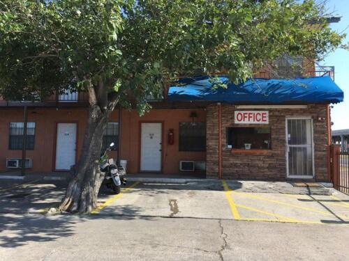 拉雷多Loma Alta Motel的前面有树的咖啡店