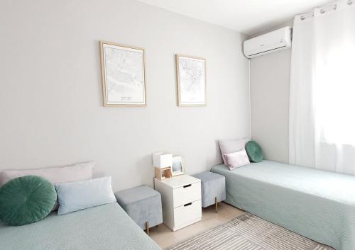 阿尔布费拉Feliz Algarve的一间卧室设有两张床、一把椅子和一个窗户。