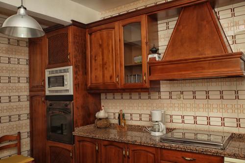卡韦苏埃拉德尔瓦列Apartamentos Lalola的一间带木制橱柜和微波炉的厨房