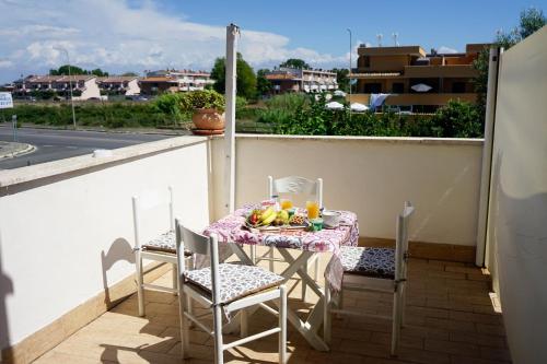 菲乌米奇诺Casa Donna di Cuori的阳台上的桌椅,上面有饭